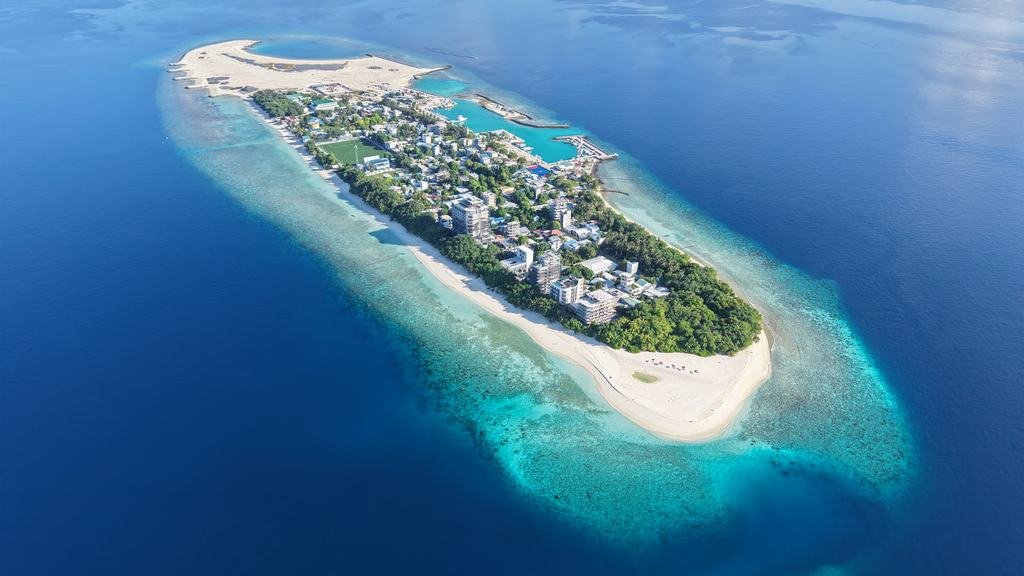 Ukulhas from the air, the whole island low in deep blue water.