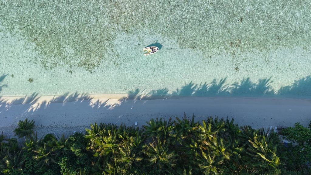 Ukulhas from the air: houses, palms and the reef edge where the lagoon turns pale.