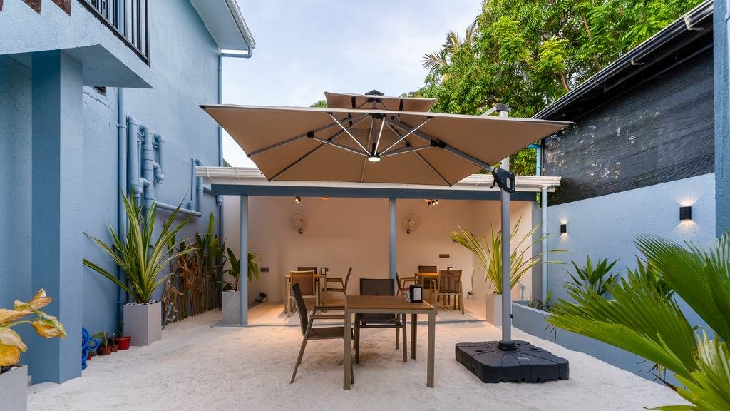 The courtyard downstairs, tables shaded by a wide parasol.